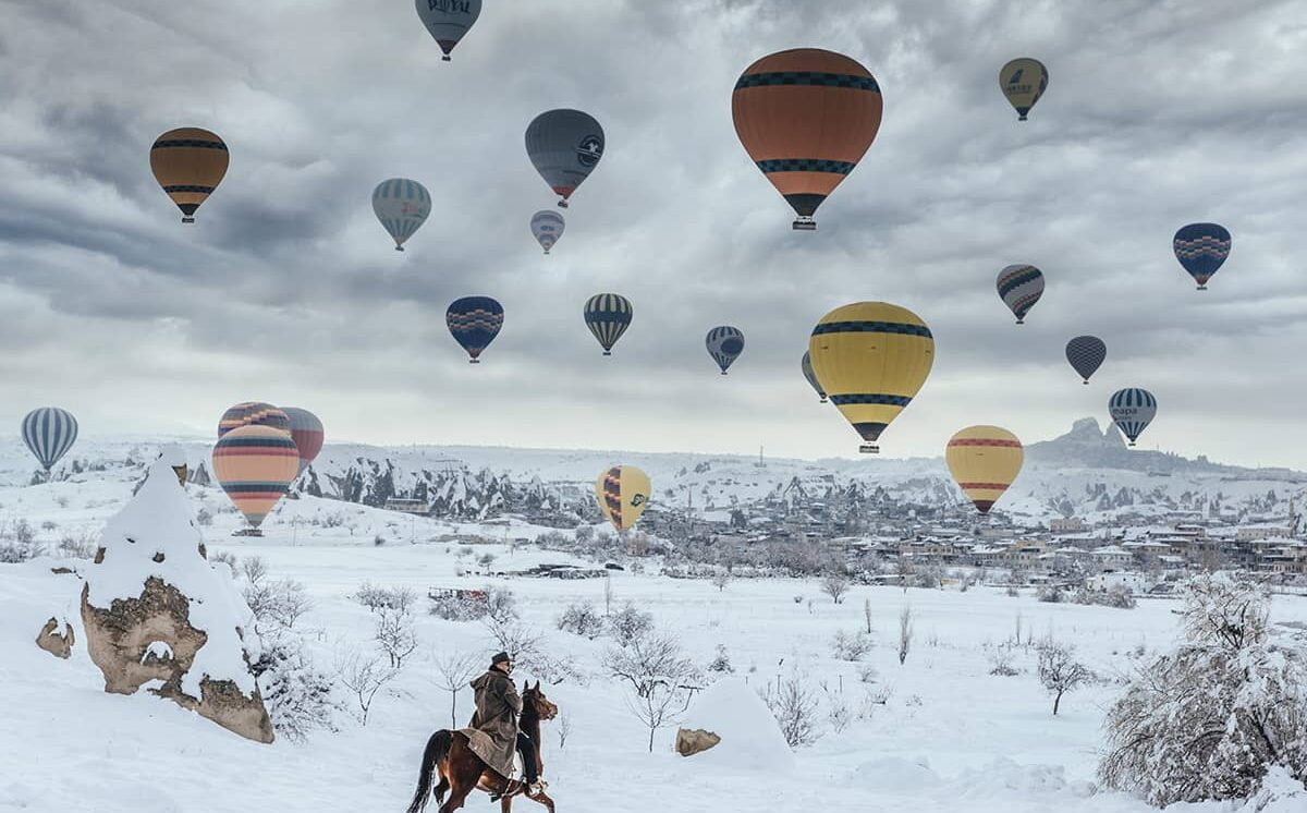 latające balony na tle zaśnieżonej Kapadocji